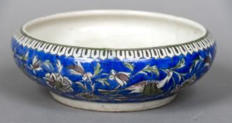 A 19th century Qajar pottery bowl Of squat form, decorated in the round with birds amongst flowers.
