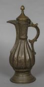 A 19th century Ottoman brass ewer Of ribbed baluster form with engraved scroll decoration,