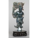 A Chinese carved moss agate group Worked as a young woman holding aloft a floral sprig,