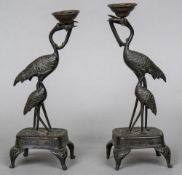 A pair of Japanese Meiji period patinated bronze candlesticks Each formed as a pair of storks.