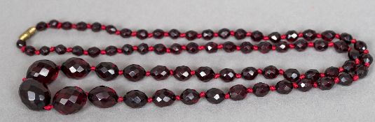 A facet cut bead necklace, possibly cherry amber 86 cm long.