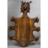 A late 19th/early 20th century Black Forest carved coat rack Surmounted with a carved stags head,