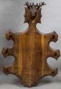 A late 19th/early 20th century Black Forest carved coat rack Surmounted with a carved stags head,