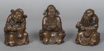 Three Chinese bronze figures of sages Variously modelled. The largest 13.5 cm high.