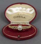 An 18 ct gold diamond set lady's Omega wristwatch The signed dial with baton markers,