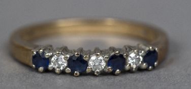 A 9 ct gold diamond and sapphire ring The four claw set sapphires interspersed by three diamonds.