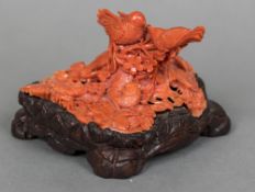 A Chinese carved coral group Worked as birds and rodents amongst floral sprays,