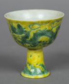 A Chinese porcelain stem cup Decorated with dragons on a yellow ground,