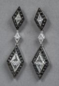 A pair of white and black diamond set 18 ct white gold drop earrings The pendants lozenge shaped.