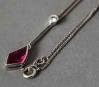 An 18 ct white gold diamond and red stone pendant Supported on an 18 ct white gold chain.