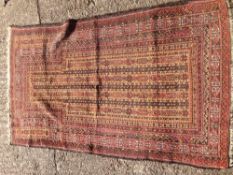 A woollen prayer rug The tan mihrab field enclosing rosette strings within geometric guard stripes