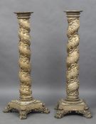 A pair of 18th century carved wooden torcheres Each of barley twist form with gilt trailing vine