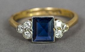 An Art Deco 18 ct gold and platinum diamond and sapphire ring The central emerald cut sapphire