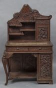 An early 20th century Chinese desk The shaped top above various shelved sections and a writing