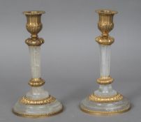 A pair of gilt metal mounted carved crystal candlesticks Each with fluted column,