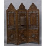 A late 19th/early 20th century North African carved three fold screen With typical pierced beaded