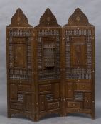 A late 19th/early 20th century North African carved three fold screen With typical pierced beaded