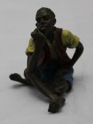 A cold painted bronze in the form of a seated man