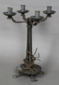 An Arts & Crafts wrought metal candelabra, with four branches above the four section column,