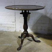 A mahogany tilt top tripod table