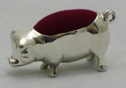 A silver pin cushion in the form of a pig