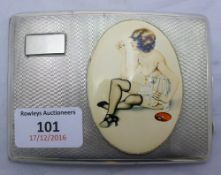 A silver cigarette case depicting a scantily clad woman