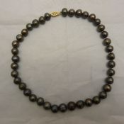 A string of black pearls with a gold clasp