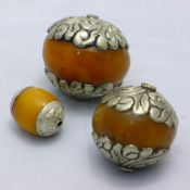 Three white metal mounted amber balls