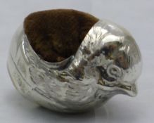A silver pin cushion in the form of a chick