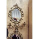 A pair of Rococo style gilt brass three branch girandole mirrors with bevel edge plates