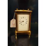 An early 20thC brass chiming carriage clock, the enamel dial with Roman numerals,