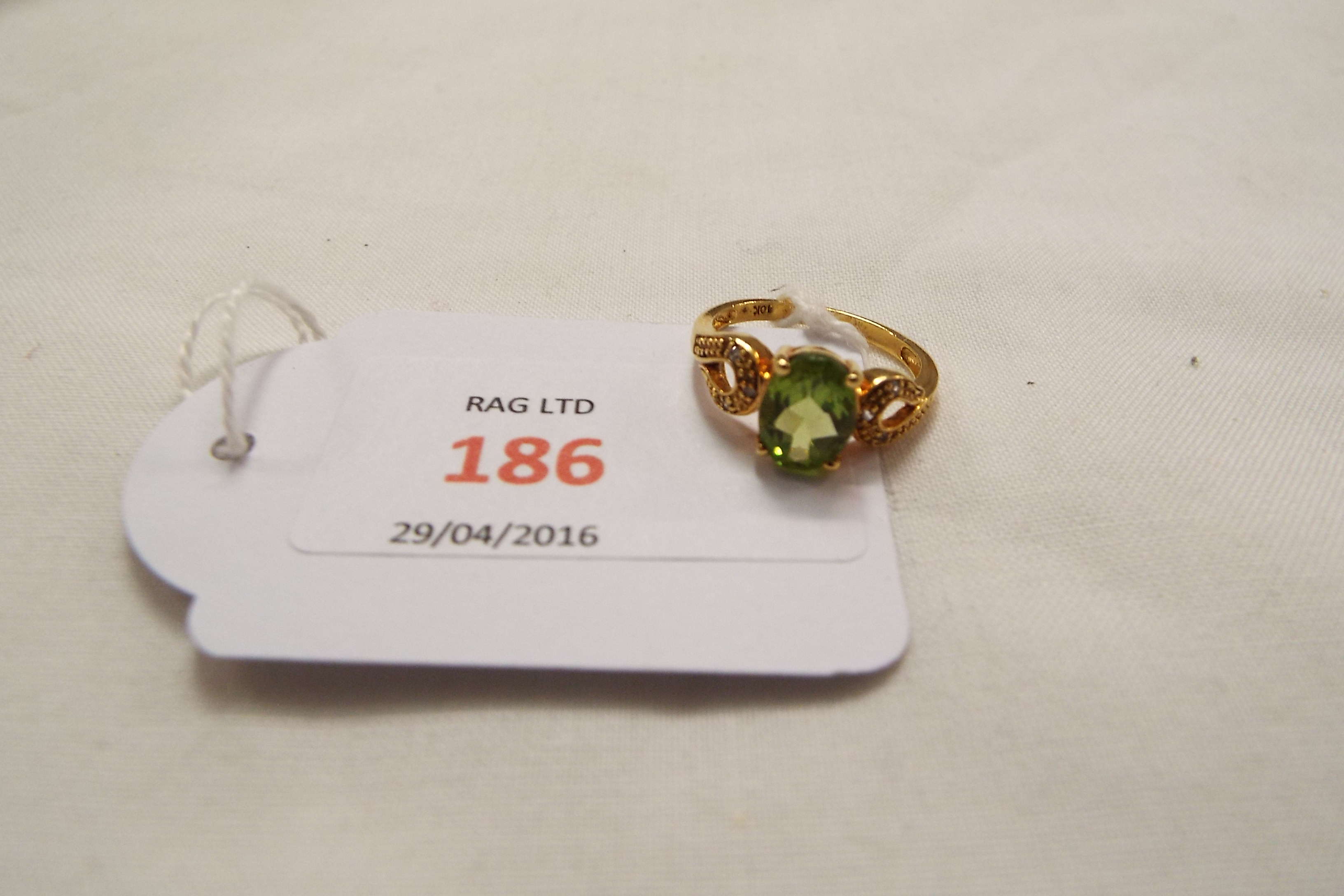 A 9ct gold ring set with peridot and clear stones,