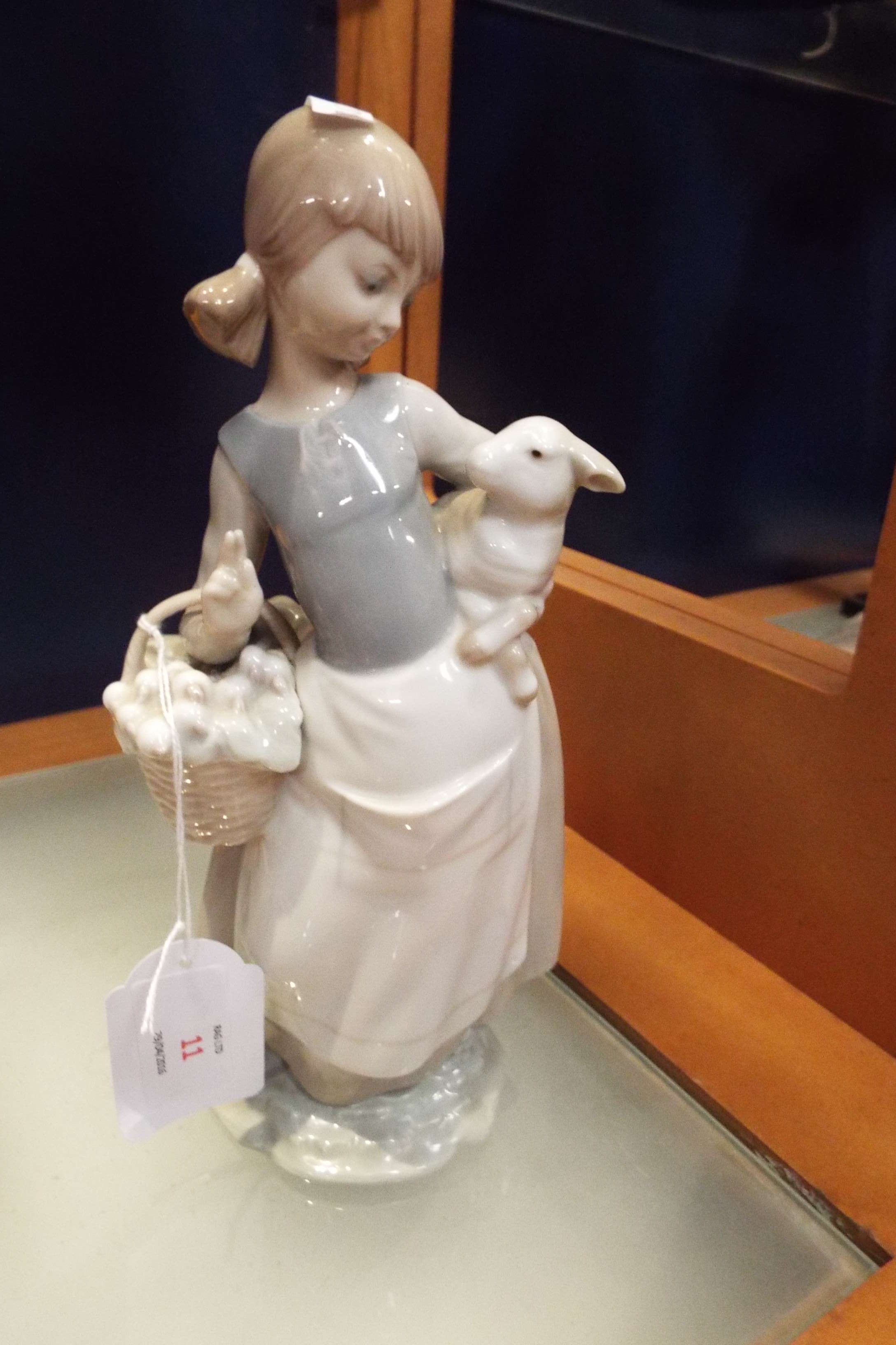 A Lladro figurine of a girl with a lamb and a basket of vegetables