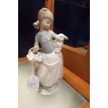 A Lladro figurine of a girl with a lamb and a basket of vegetables