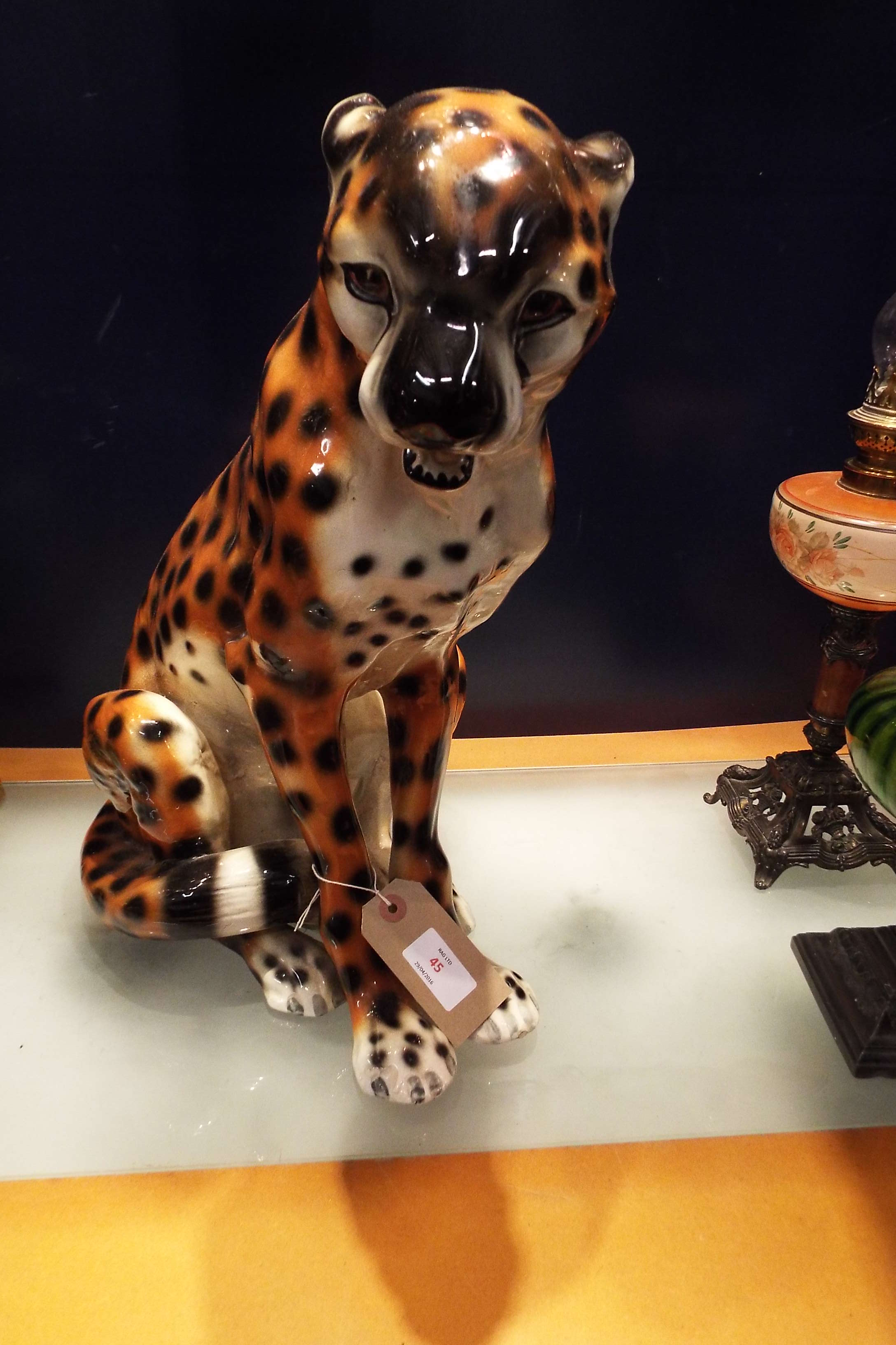 A large ceramic fireside seated cheetah