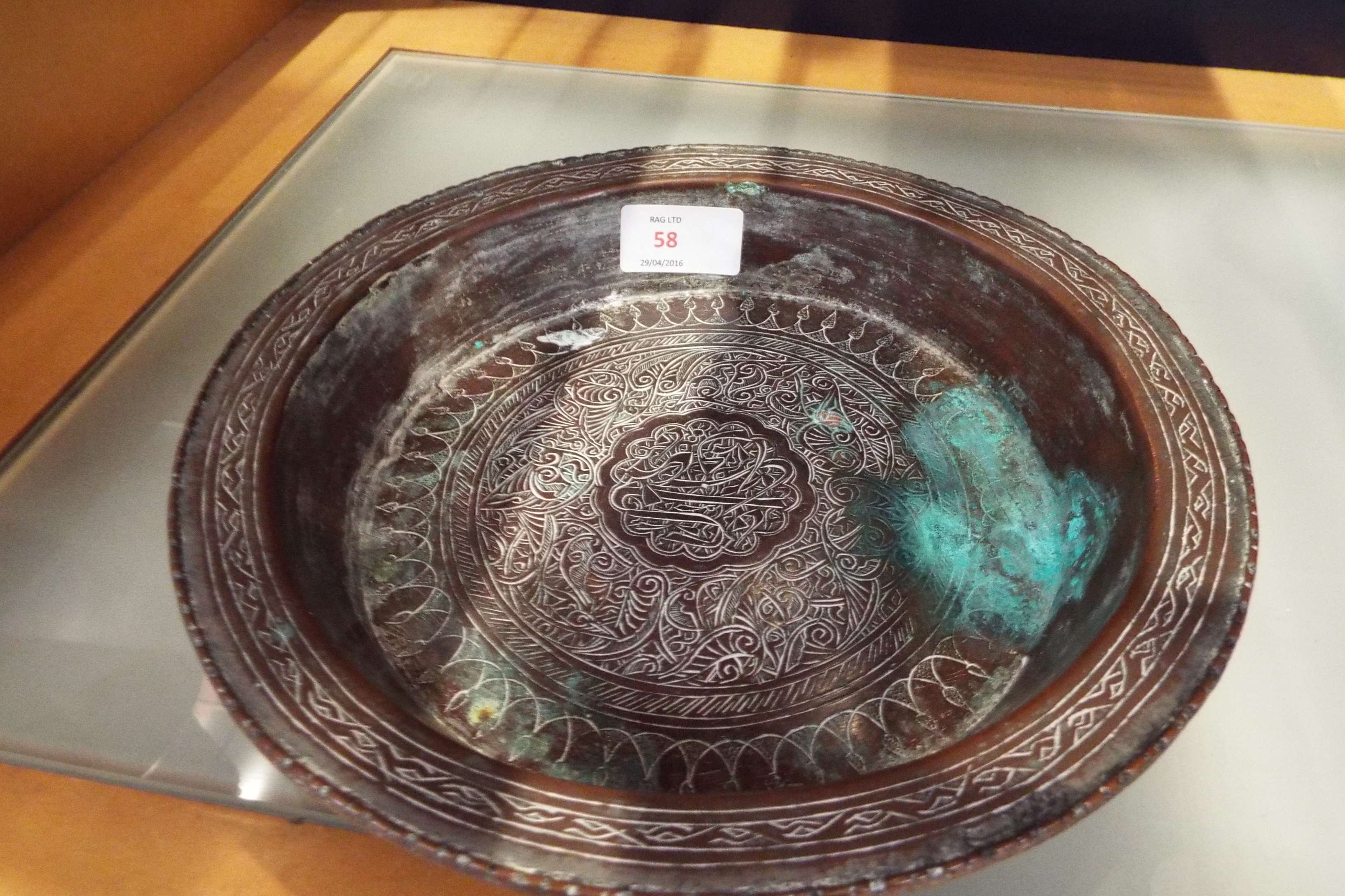 A late 19thC Indian brass bowl engraved with floral scrolls and script to central panel