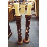 A pair of wooden twist floor standing candle holders