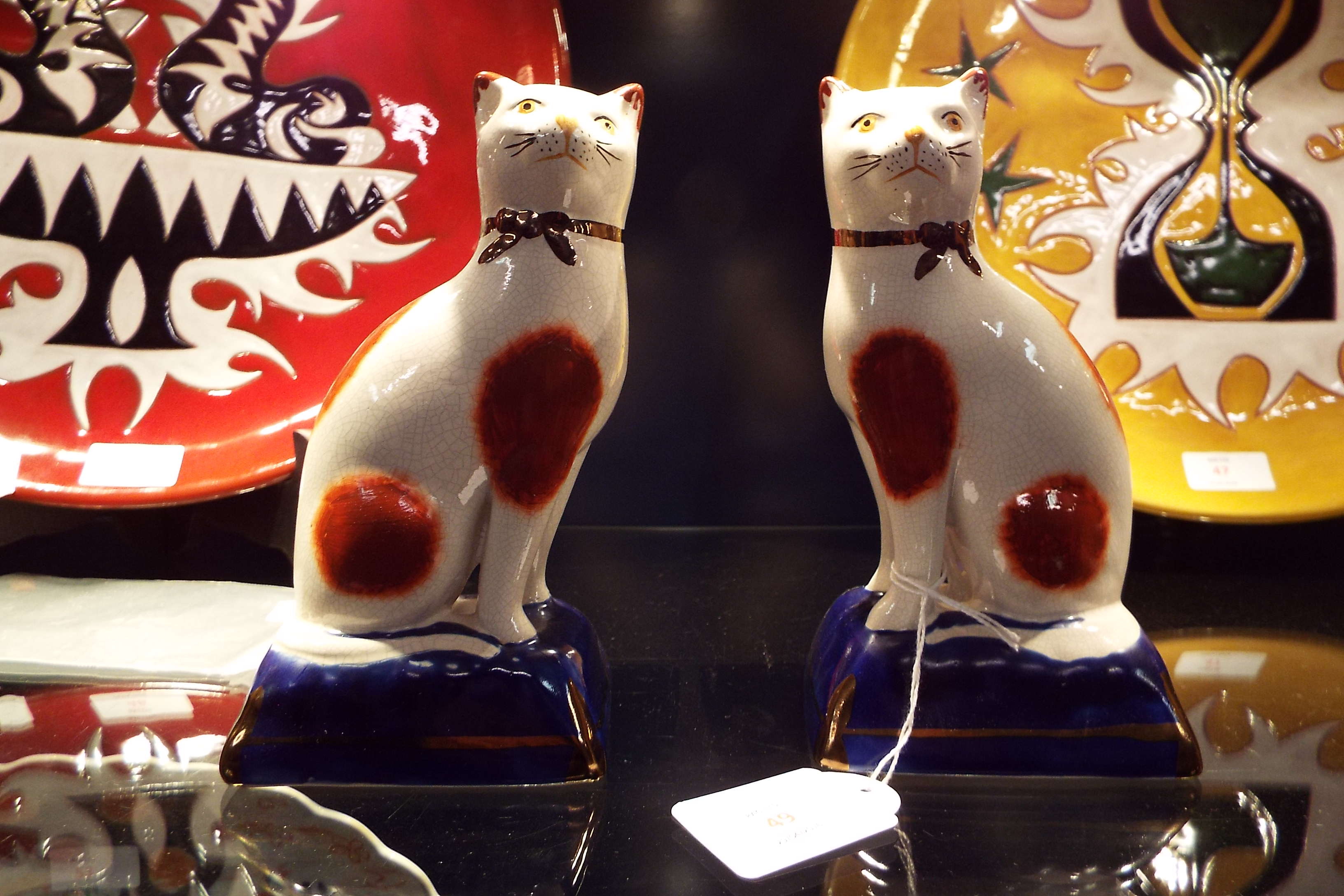 A pair of hand painted Staffordshire Pottery seated cats
