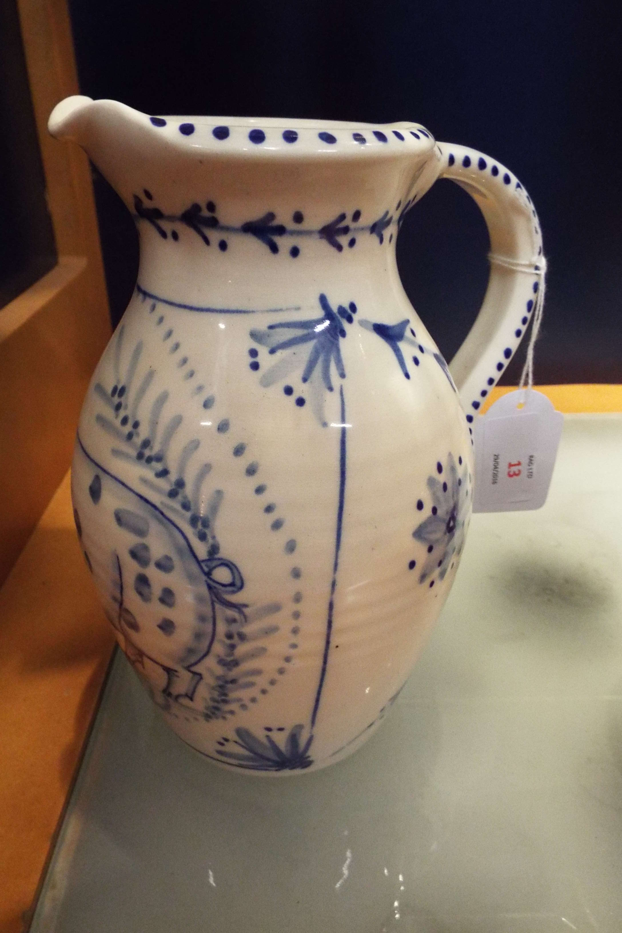A Rye Pottery white glazed water jug with blue and white decoration of a pig,