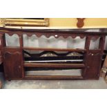 An 18thC oak wall rack having three plate shelves flanked by arch shaped cupboards