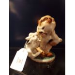 A 19thC Continental ceramic figure group of a seated lion holding a rabbit