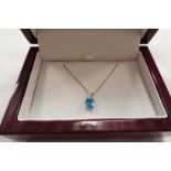 A 9ct white gold topaz pendant and chain,