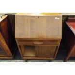 A mid-20thC oak bureau the sloping fall enclosing pigeon holes and single drawer above a long