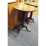 A 19thC oak circular wine table raised on a turned cannon barrel support and three out swept feet