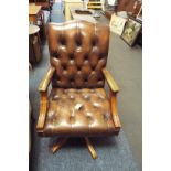 A 20thC leather button back desk chair with adjustable swivel base and raised on five out swept