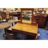 An Edwardian light oak dressing table with bevel mirror back over two short drawer and raised on