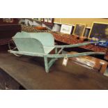 A vintage green painted childs wheel barrow