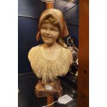 A Goldscheider female bust, paint work very faded and chip to rear of scarf,