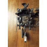 A Black Forest cuckoo clock having applied leaf and bird decoration