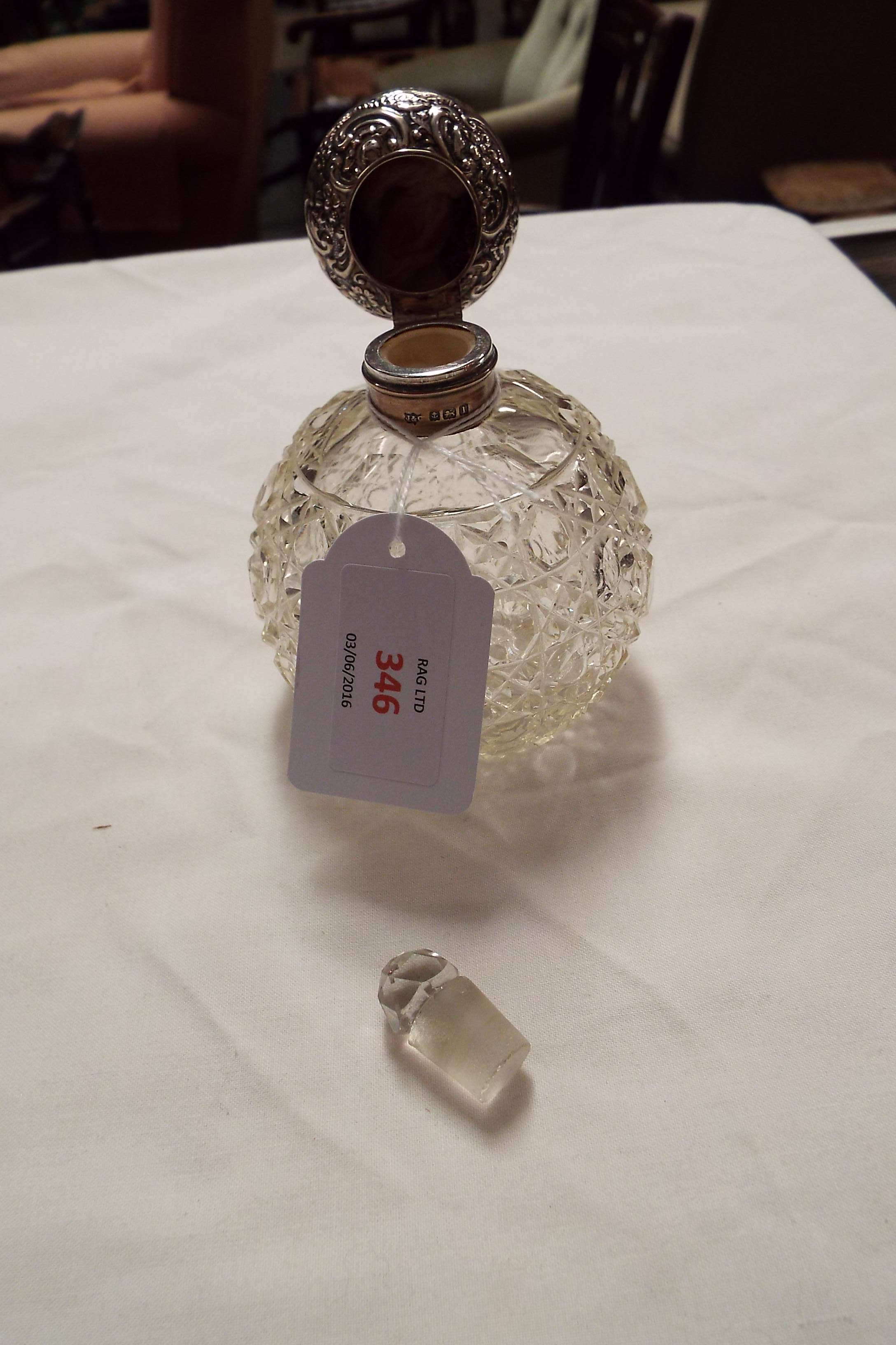 A Birmingham 1910 silver topped perfume bottle having embossed scroll decoration with hob-nail cut - Image 2 of 3